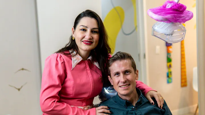 Dra. Bruna Meotti abraçando Eduardo Meotti, sentado na cadeira do consultório infantil da Odonto Fun